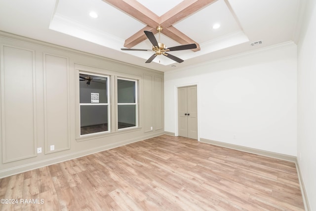 empty room featuring ceiling fan, light hardwood / wood-style floors, ornamental molding, and coffered ceiling