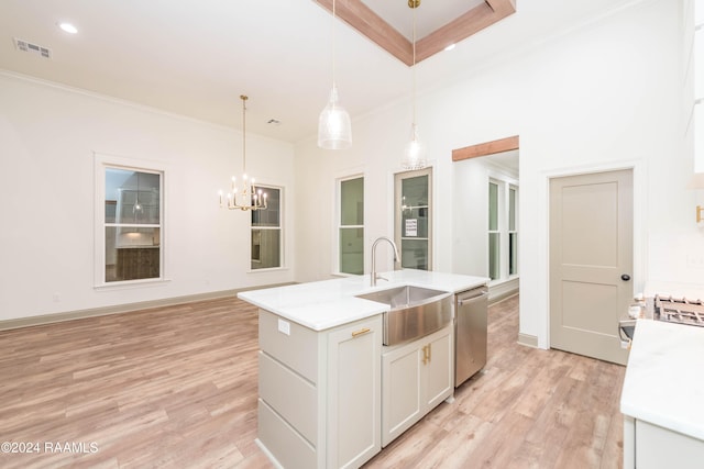 kitchen with sink, hanging light fixtures, stainless steel dishwasher, a center island with sink, and white cabinets