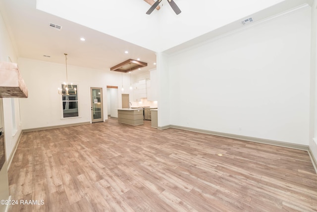 unfurnished living room featuring light wood-type flooring, ceiling fan, and ornamental molding