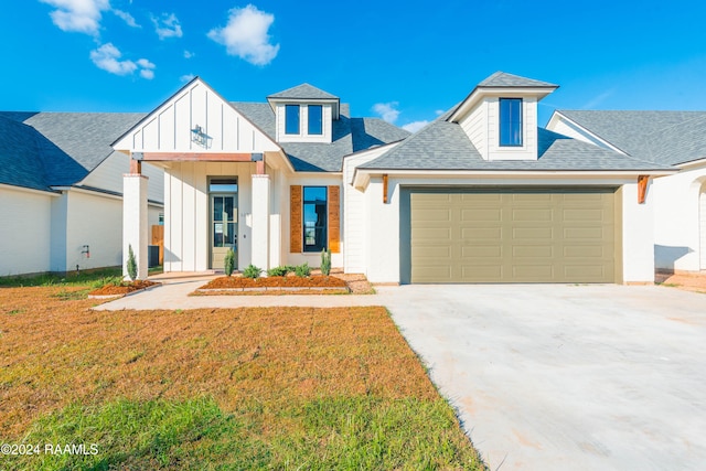 modern farmhouse with a front lawn and a garage