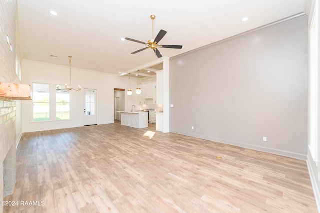 unfurnished living room with ceiling fan with notable chandelier, light hardwood / wood-style flooring, crown molding, and sink