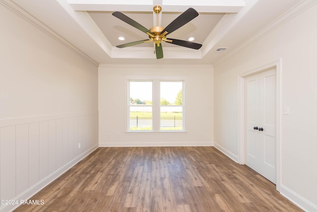 unfurnished room with hardwood / wood-style floors, a tray ceiling, ceiling fan, and ornamental molding