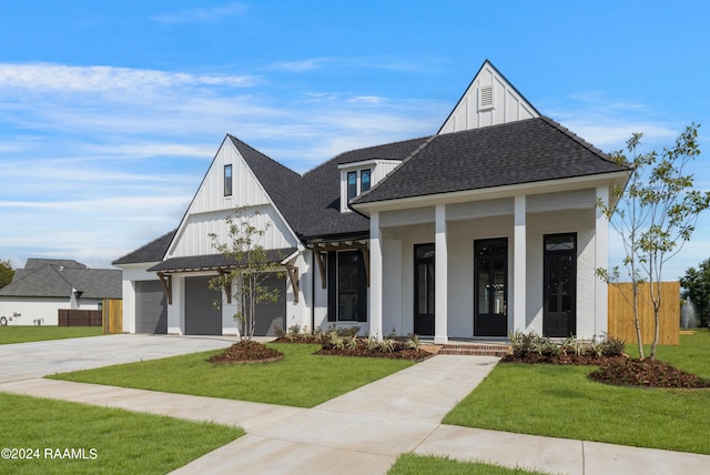 modern inspired farmhouse featuring a porch, a garage, and a front yard