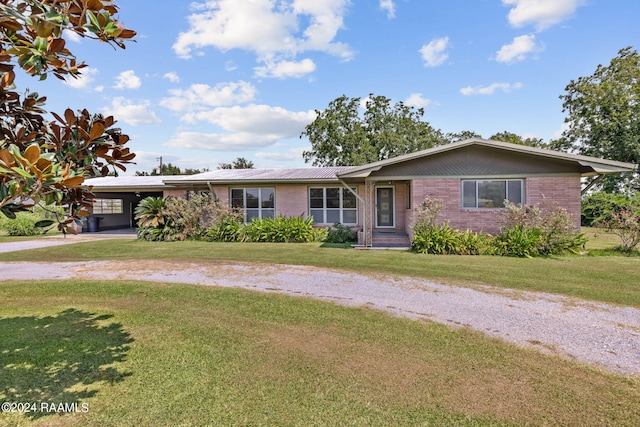 ranch-style house featuring a front lawn and a carport