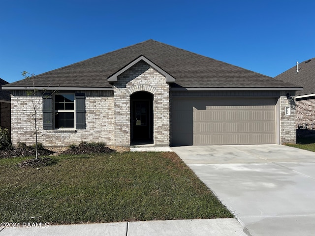 view of front of house with a garage and a front lawn