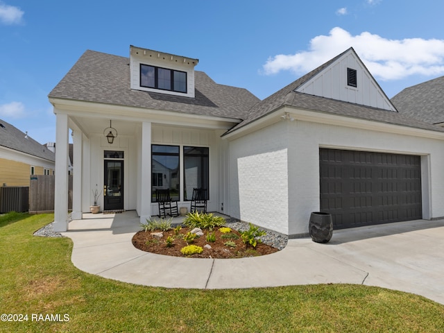 view of front facade featuring a garage, a porch, and a front yard