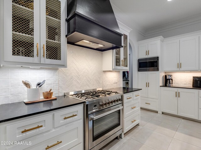 kitchen featuring decorative backsplash, custom exhaust hood, appliances with stainless steel finishes, white cabinetry, and crown molding