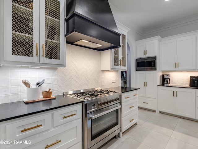 kitchen with premium range hood, ornamental molding, high end stainless steel range, built in microwave, and dark countertops