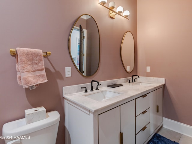 bathroom with tile patterned flooring, toilet, and double sink vanity