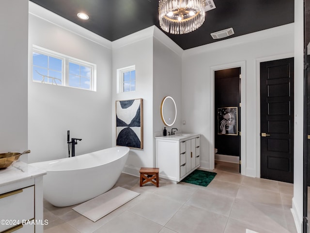 bathroom with a notable chandelier, vanity, visible vents, a soaking tub, and tile patterned floors