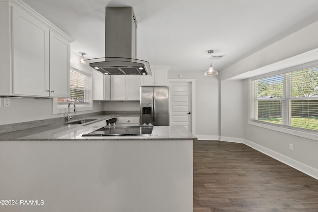 kitchen with a peninsula, island exhaust hood, stainless steel refrigerator with ice dispenser, white cabinetry, and a sink