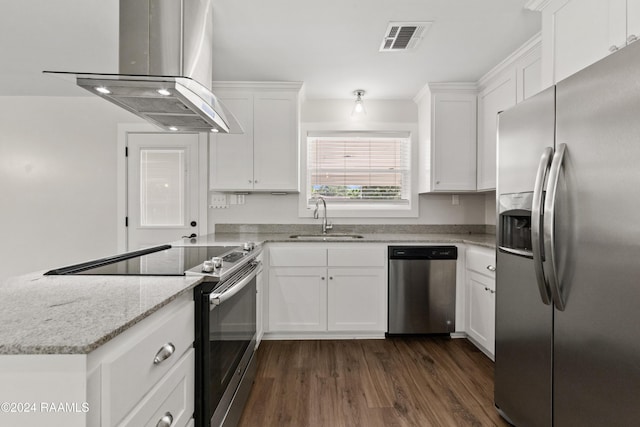 kitchen featuring visible vents, a sink, white cabinetry, appliances with stainless steel finishes, and wall chimney range hood