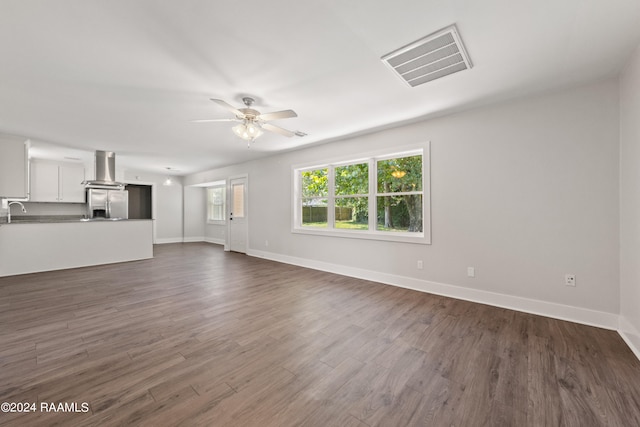 unfurnished living room featuring ceiling fan, sink, and hardwood / wood-style floors