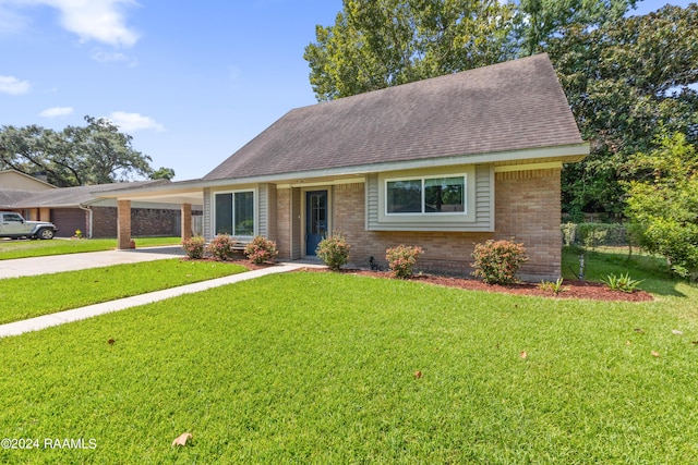 view of front facade featuring an attached carport, concrete driveway, brick siding, and a front yard