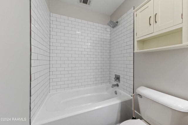 bathroom featuring toilet and tiled shower / bath