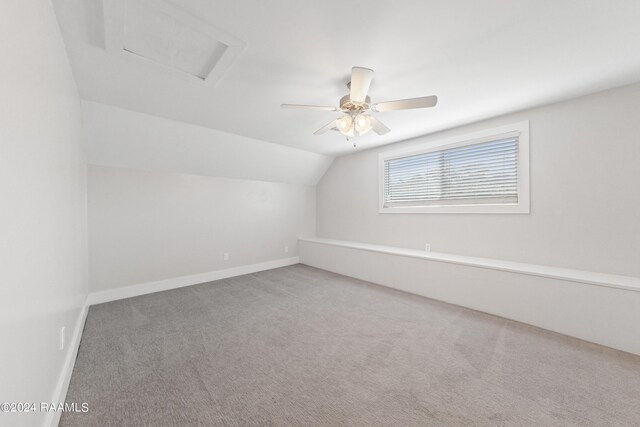 carpeted spare room featuring ceiling fan and lofted ceiling