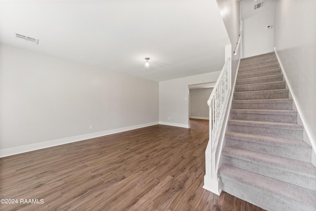 stairway featuring visible vents, baseboards, and wood finished floors