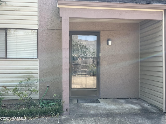 view of exterior entry featuring stucco siding