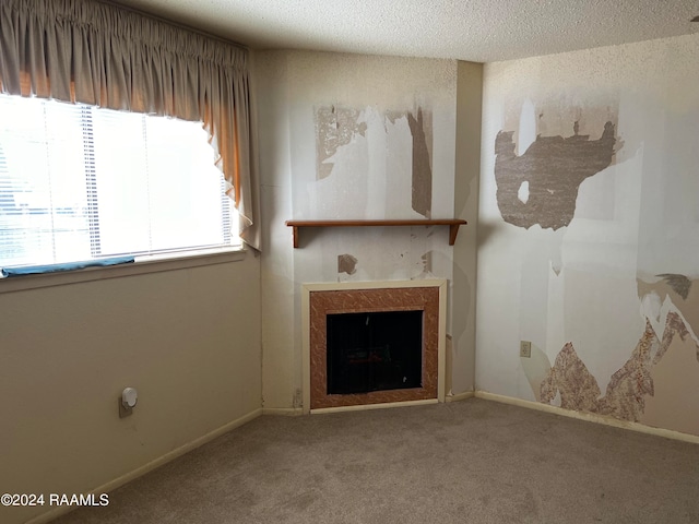 unfurnished living room featuring carpet and a textured ceiling