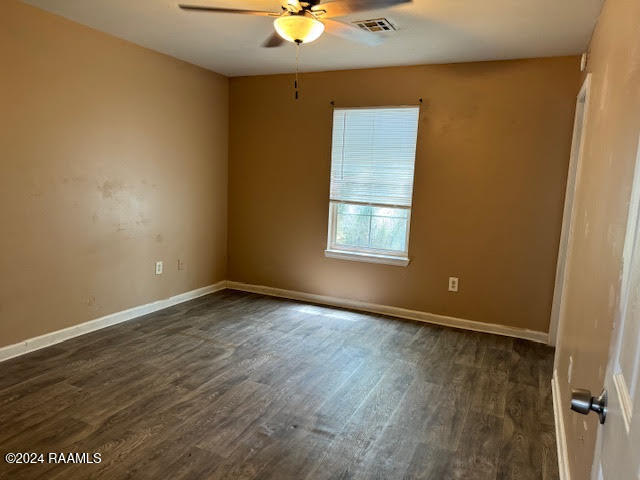 empty room featuring dark hardwood / wood-style flooring and ceiling fan