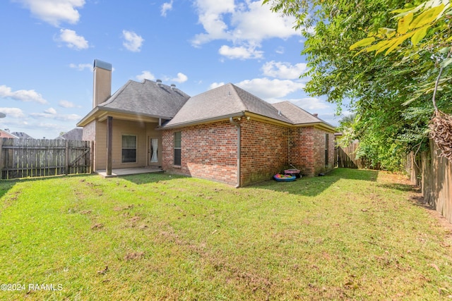 back of property featuring a patio area and a yard