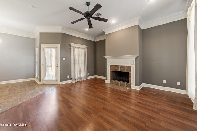 unfurnished living room featuring wood-type flooring, a fireplace, crown molding, and ceiling fan