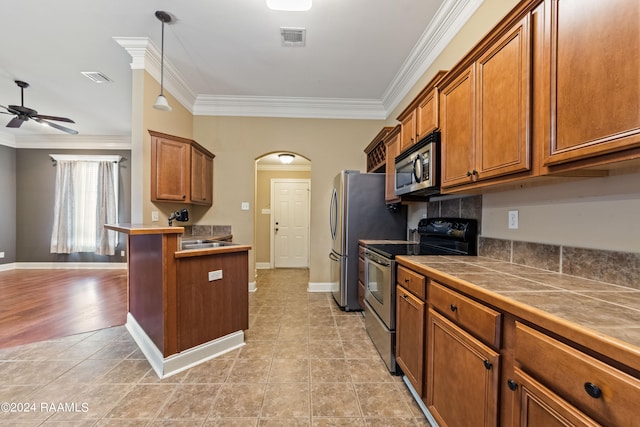 kitchen featuring ornamental molding, ceiling fan, appliances with stainless steel finishes, and decorative light fixtures