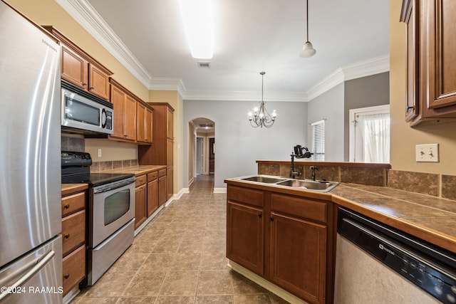 kitchen with ornamental molding, a notable chandelier, stainless steel appliances, and sink