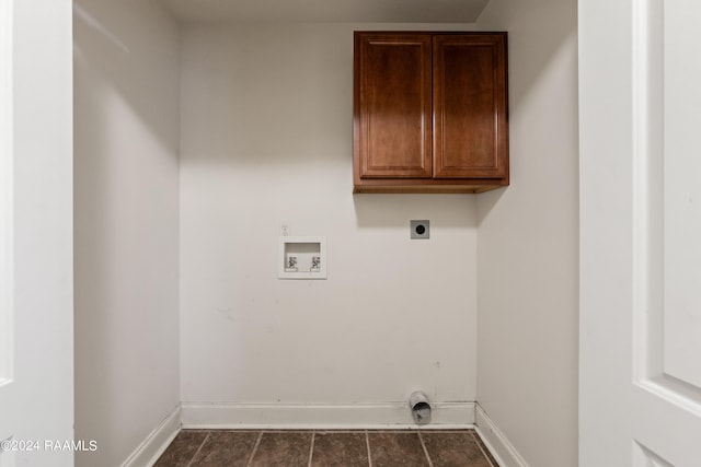 clothes washing area featuring hookup for an electric dryer, washer hookup, dark tile patterned flooring, and cabinets