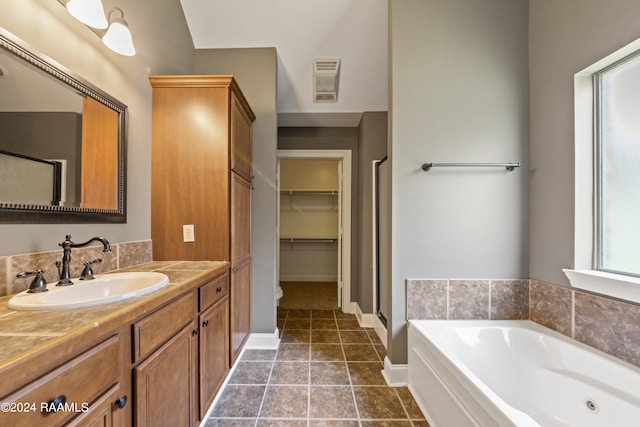 bathroom featuring vanity, plus walk in shower, and tile patterned floors