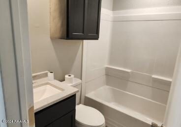 full bathroom with vanity, shower / tub combination, and toilet