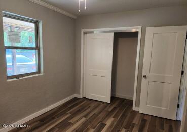 unfurnished bedroom featuring a closet and dark hardwood / wood-style floors