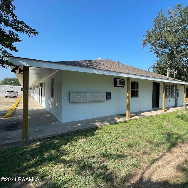 back of property with a yard and an AC wall unit