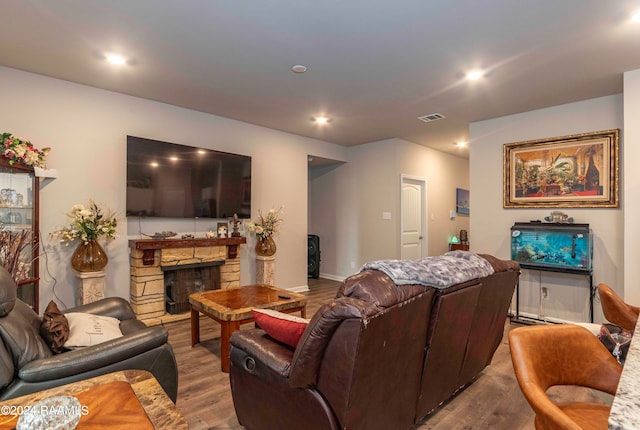 living room featuring hardwood / wood-style floors and a stone fireplace