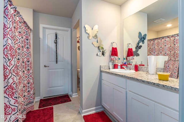 bathroom featuring toilet, tile patterned flooring, and vanity