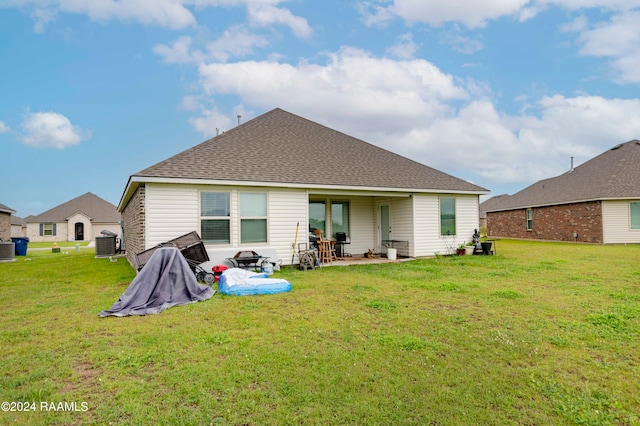 rear view of property featuring a patio area, a yard, and central air condition unit