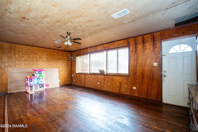 entryway with plenty of natural light, wood walls, ceiling fan, and dark hardwood / wood-style floors