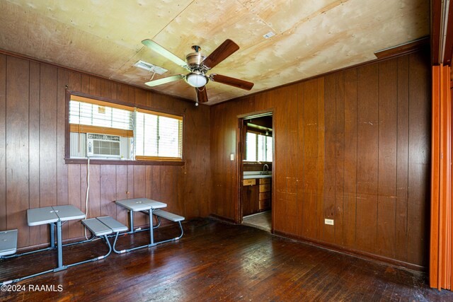 miscellaneous room with wood walls, ceiling fan, and dark hardwood / wood-style flooring