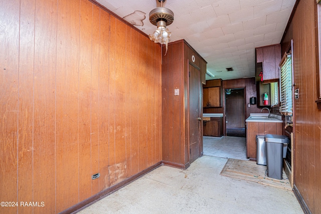 kitchen featuring wood walls and sink