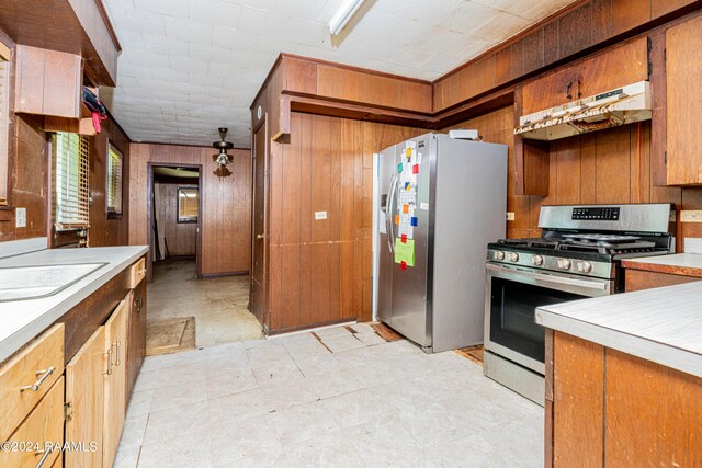 kitchen with stainless steel appliances and wood walls