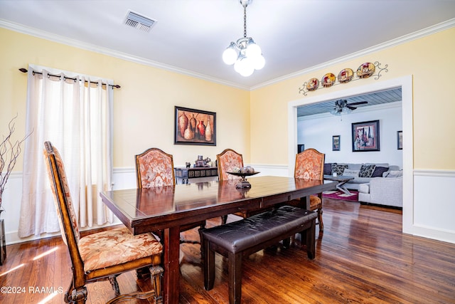 dining space featuring dark wood finished floors, visible vents, an inviting chandelier, and ornamental molding
