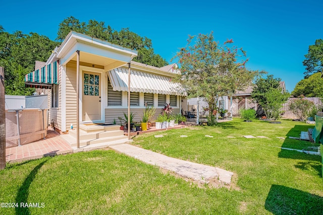 back of property featuring a yard and fence