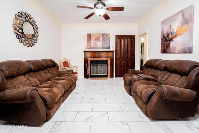 living area featuring a glass covered fireplace, crown molding, a ceiling fan, and marble finish floor