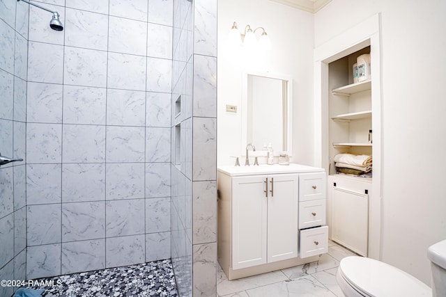 full bath with toilet, marble finish floor, built in features, tiled shower, and vanity