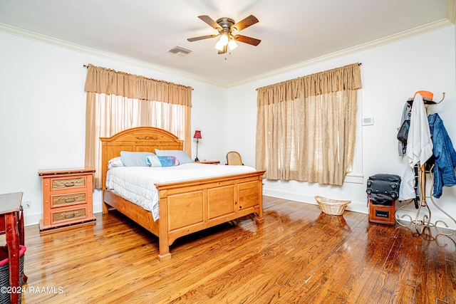 bedroom featuring visible vents, a ceiling fan, light wood-style floors, and ornamental molding