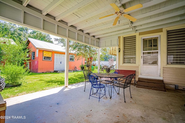 view of patio featuring outdoor dining area, an outbuilding, and ceiling fan