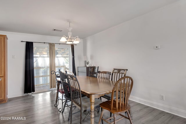 dining room with a notable chandelier, crown molding, and dark hardwood / wood-style flooring