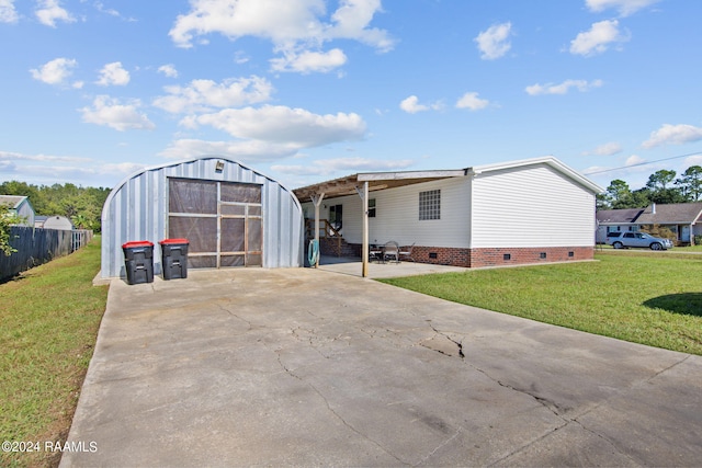 view of front of house featuring a shed, a carport, and a front yard