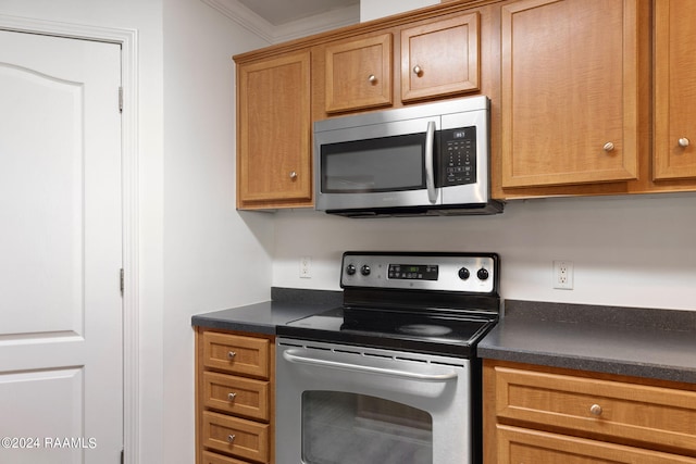 kitchen with ornamental molding and appliances with stainless steel finishes