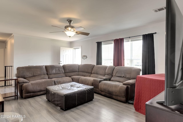 living room with ceiling fan, light wood-type flooring, and crown molding